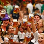 Revellers toast after getting the first beer in the traditional one-litre “Masskrug” beer mugs at  the opening day of the Munich Oktoberfest at the Theresienwiese in Munich